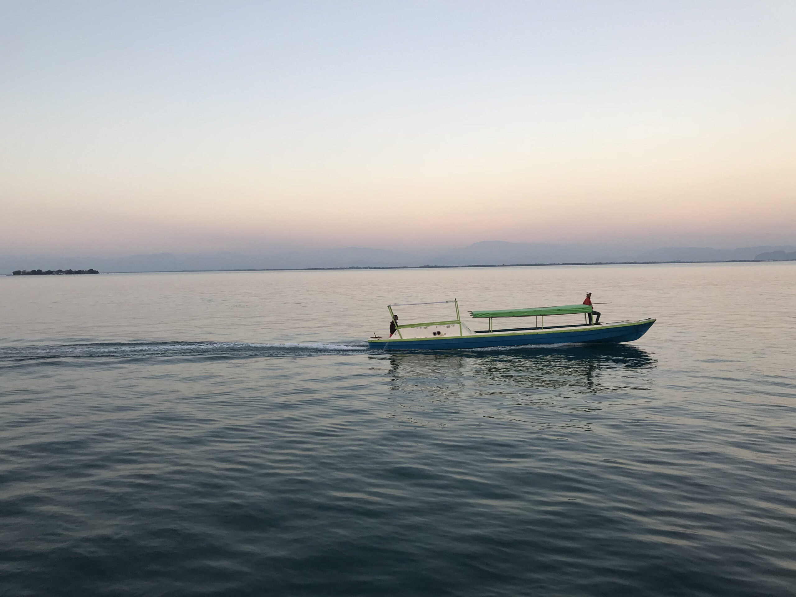 Small boat motors along the water.